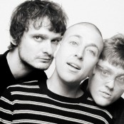 The three members of MOULD with their heads pressed together